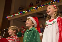 Kids singing joyful Christmas songs on stage during a holiday play